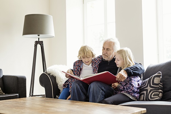 Grandfather reading book to grandchildren